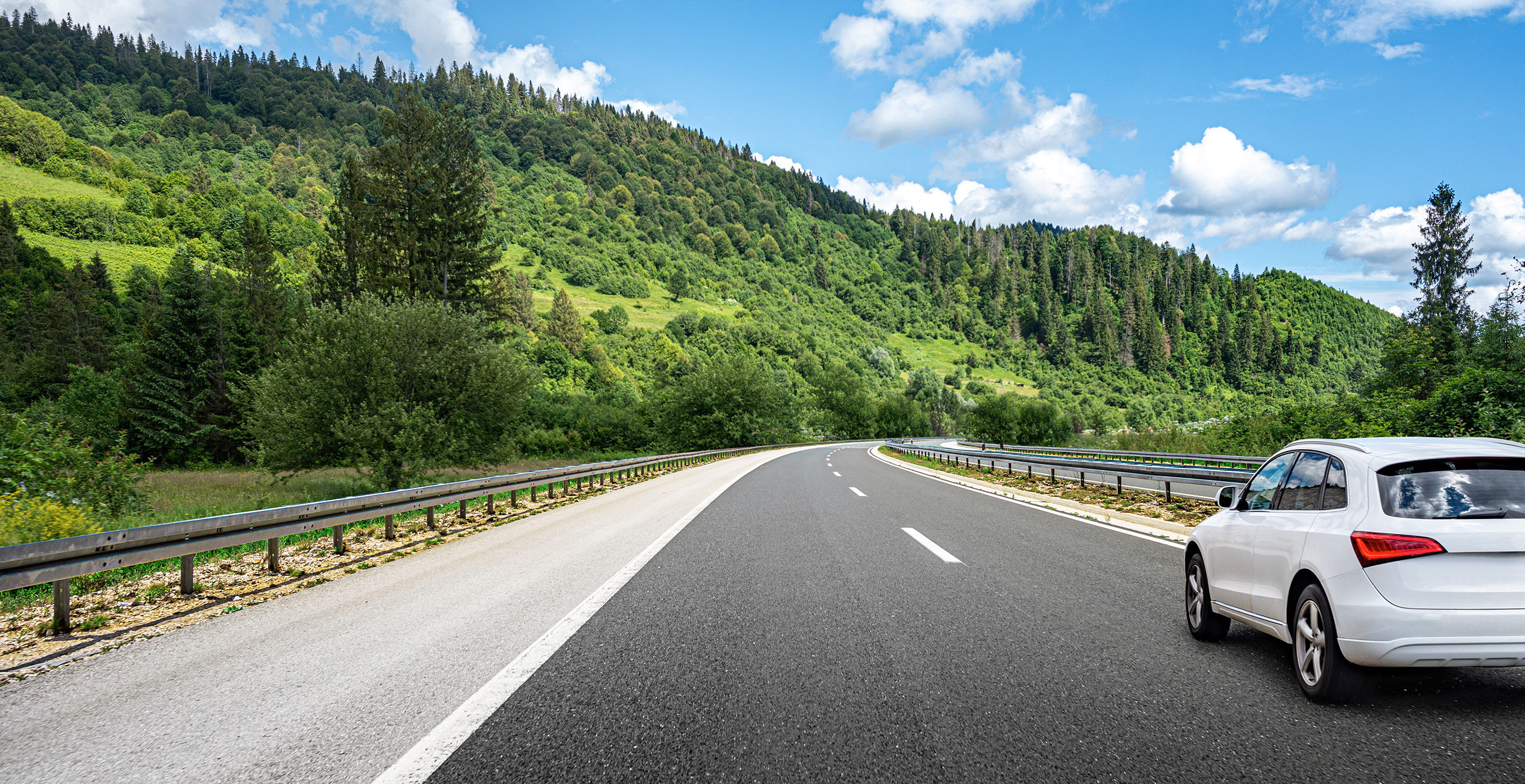 weißes Auto fährt auf einer Landstraße